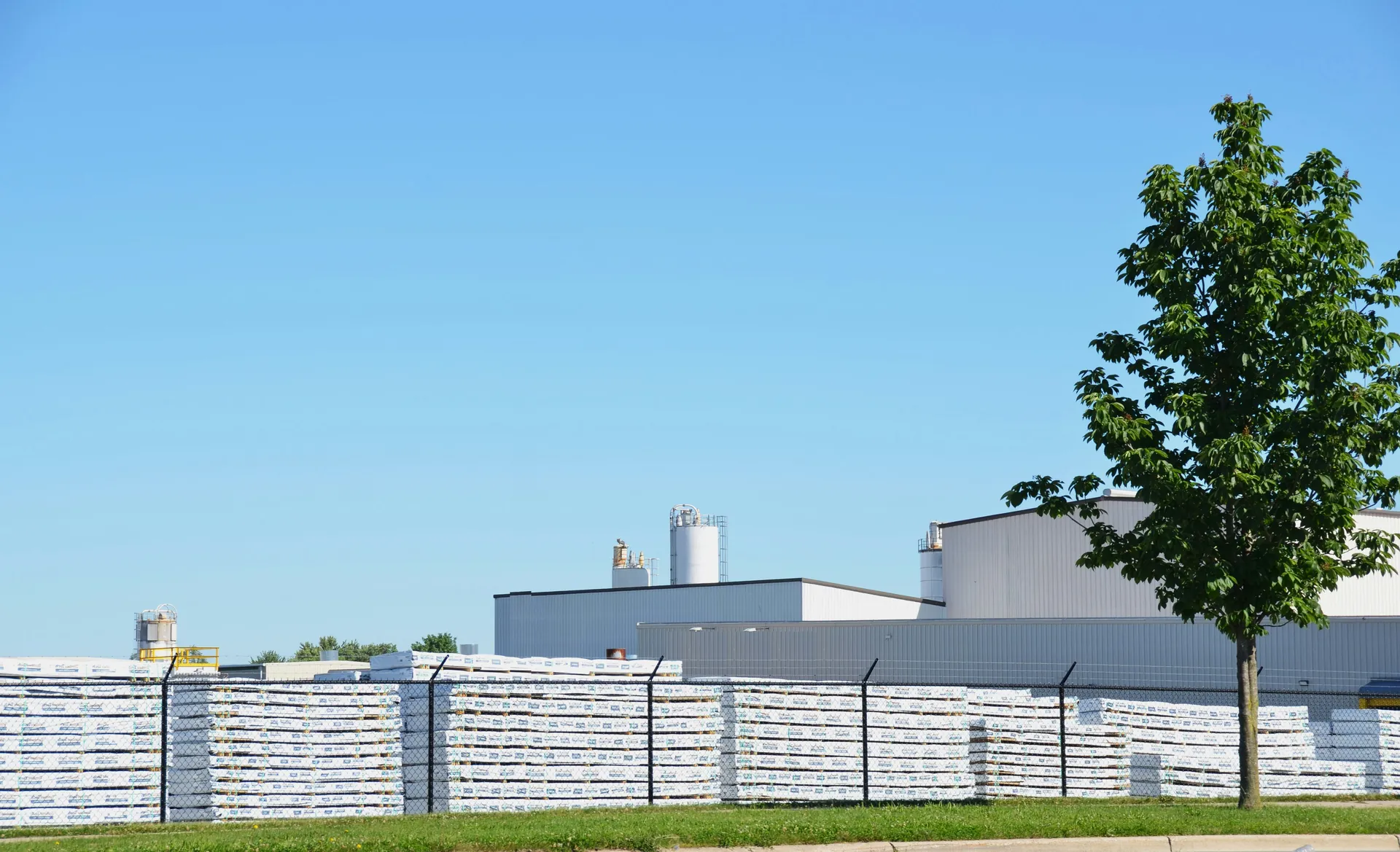 Site industriel avec b&acirc;timents en bardage, silos et stockage ext&eacute;rieur de palettes